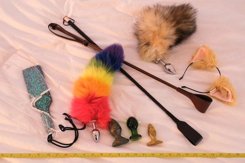 sex toys and accessories including a fuzzy rainbow butt plug